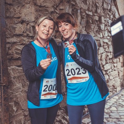 Zwei Finisherinnen zeigen ihre Medaillen nach dem Stolberger Schloss-Lauf.